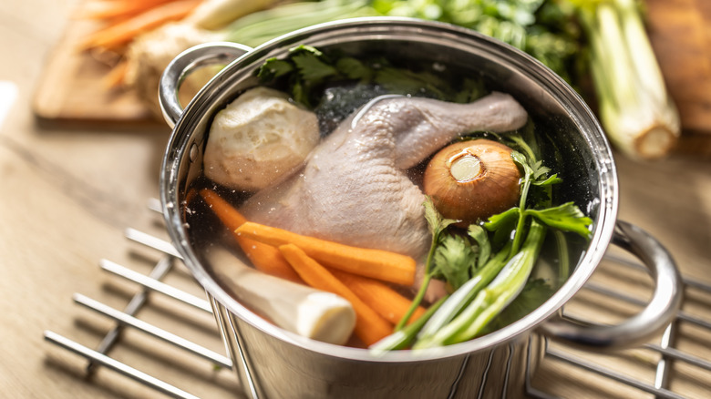 A stock pot full of chicken thighs and veggies for making stock