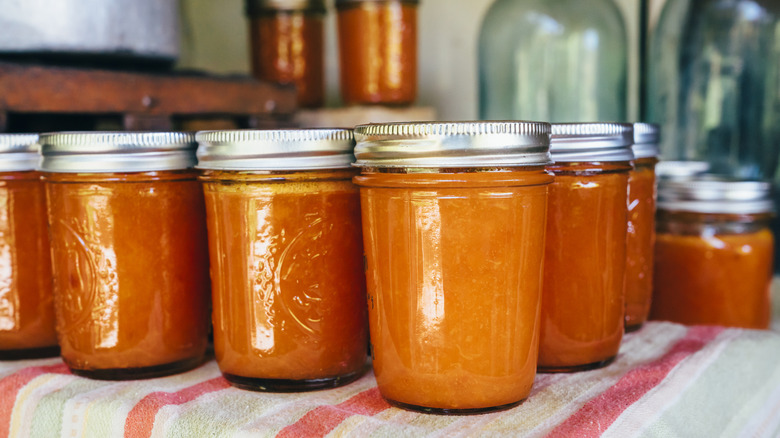 several rows of canned mason jars filled with fruit vegetable preservation