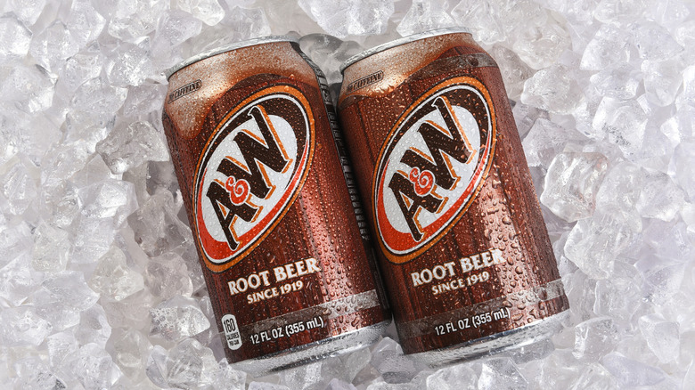 Two cans of root beer on ice