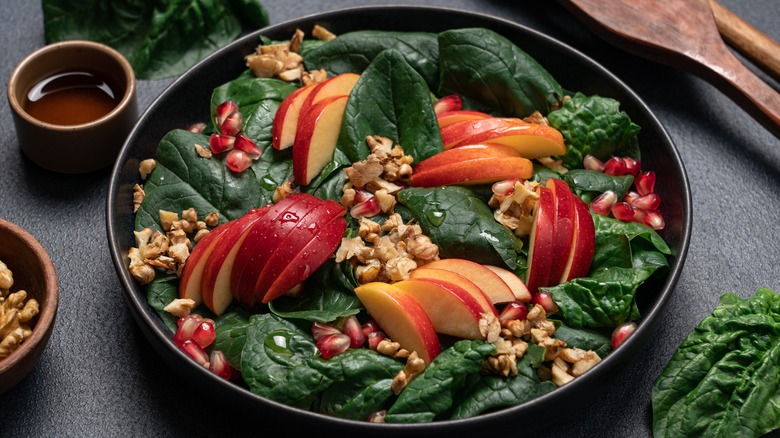 Spinach salad with apples, walnuts, and pomegranate seeds