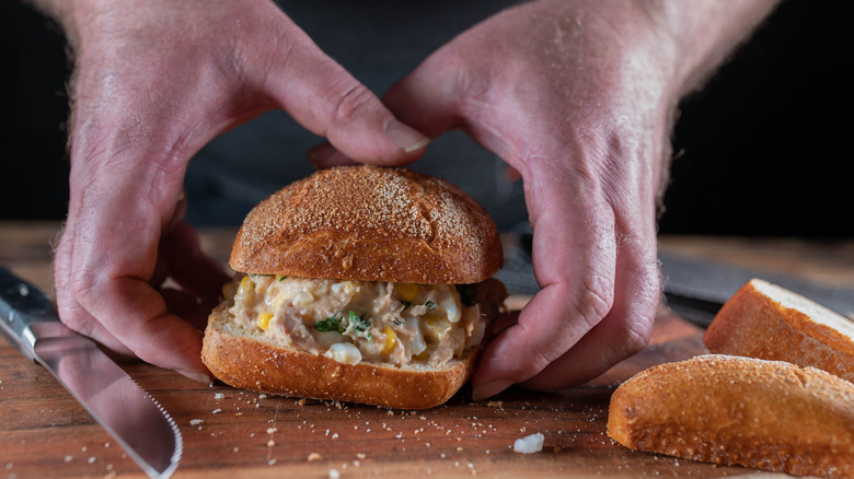 hands holding a tuna salad sandwich