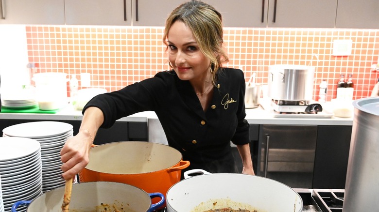 Giada De Laurentiis in restaurant kitchen stirring pots of food