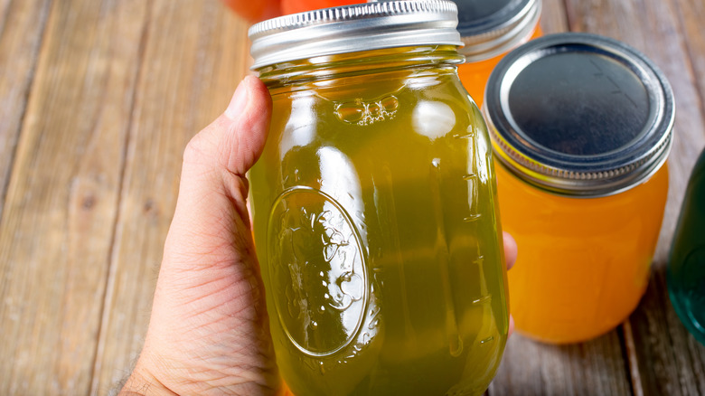 Hand holding jar of pickle juice