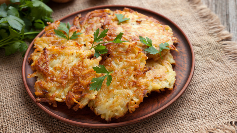 Latkes on a brown plate.