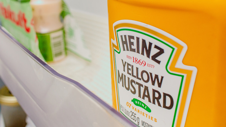 A bottle of Heinz yellow mustard in the fridge.