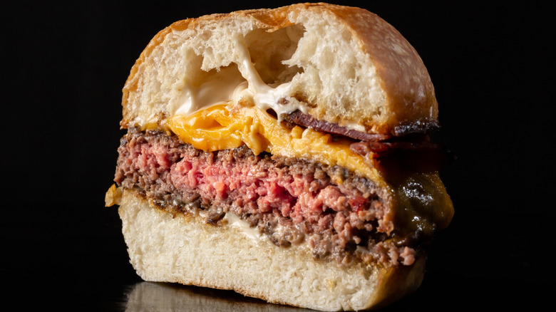 Medium-rare cheeseburger cut in half