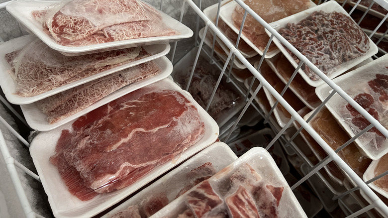 A variety of frozen beef steak in a freezer