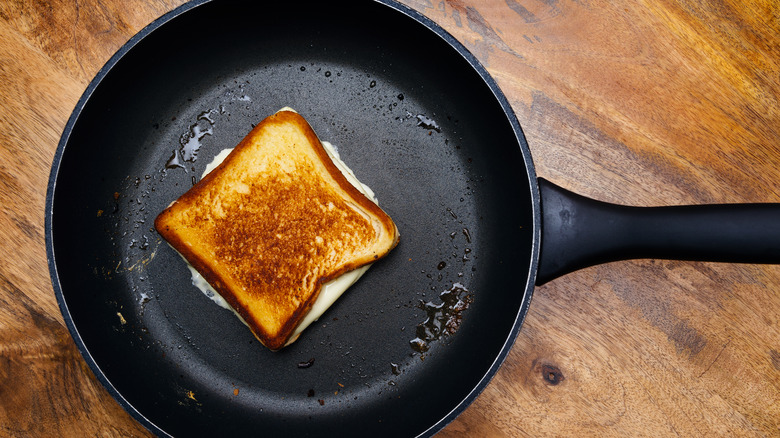 Grilled cheese sandwich cooking in pan