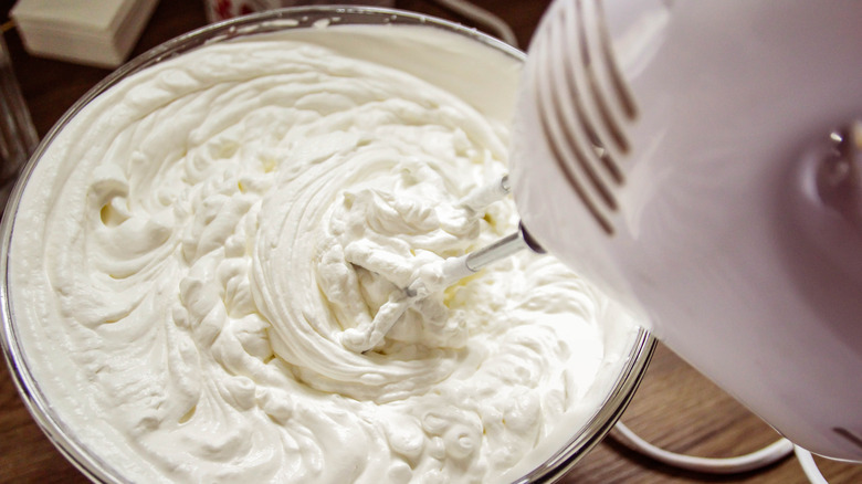 whipped cream being mixed with electric mixer