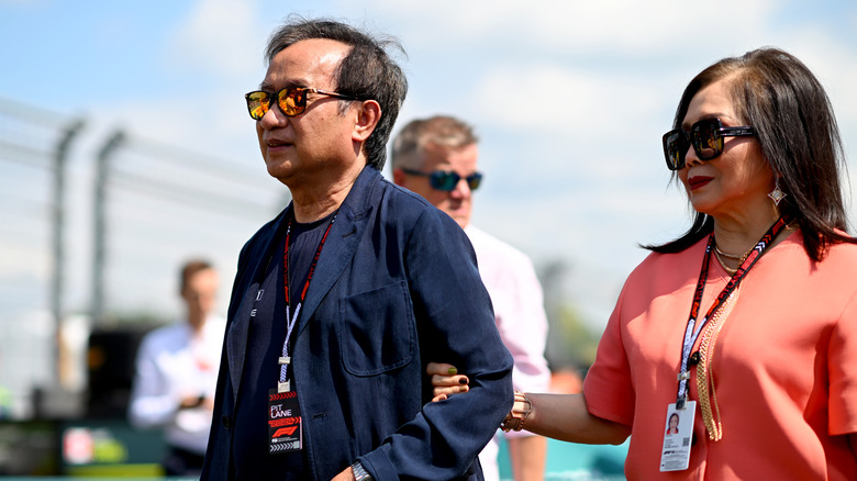 A man and woman walk on a race track