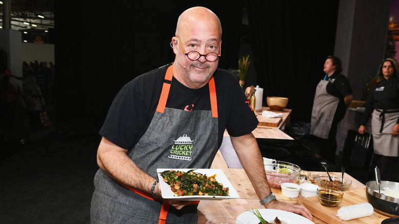 Andrew Zimmern holding food