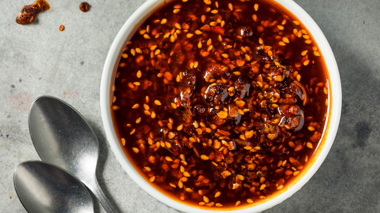 A bowl of chili crisps with two spoons set aside.