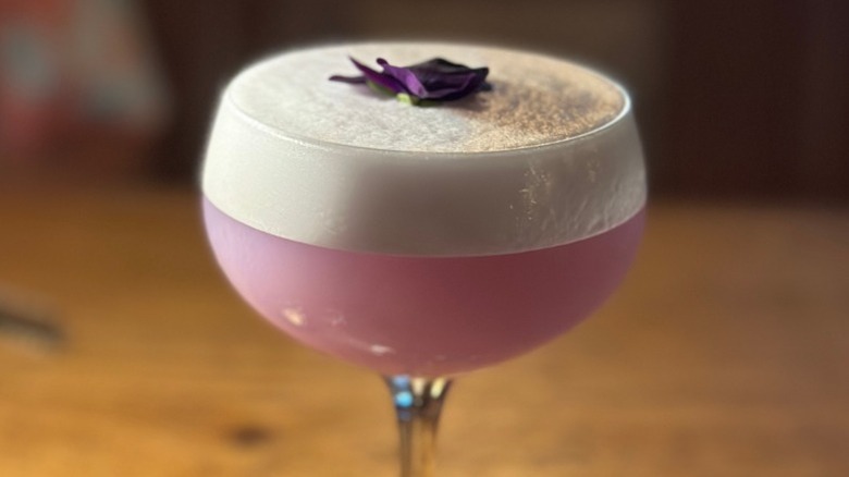 foamy pale purple cocktail in a coupe glass.