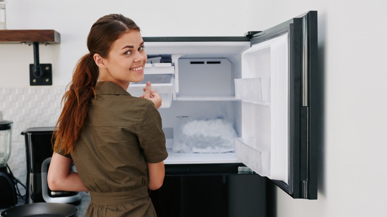 woman getting ice cubes from freezer