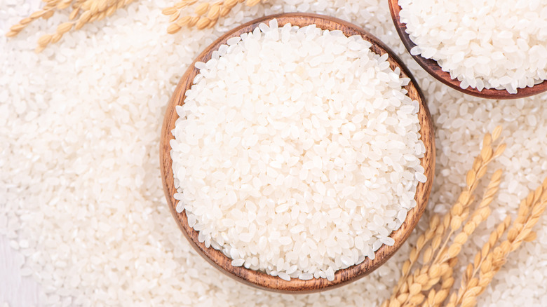 Uncooked sushi rice in a brown bowl