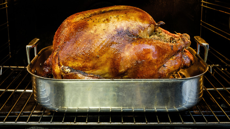 A baked Thanksgiving turkey in a deep pan in an oven