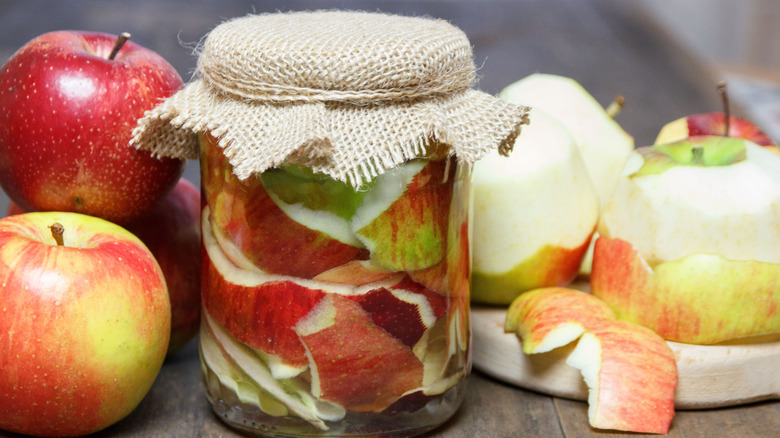 A jar of homemade apple cider vinegar with apples