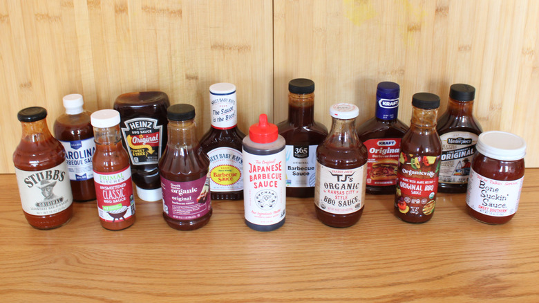 Assorted barbecue sauce brands in front of a wooden background