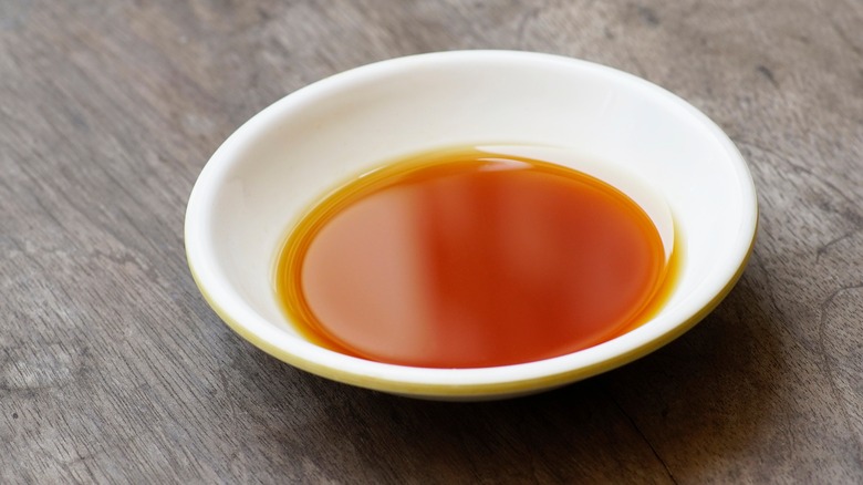 A small white bowl filled with a reddish-brown fish sauce.