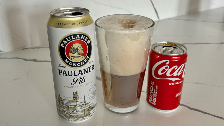 a beer can, glass of beer and coca-cola, and can of coca-cola