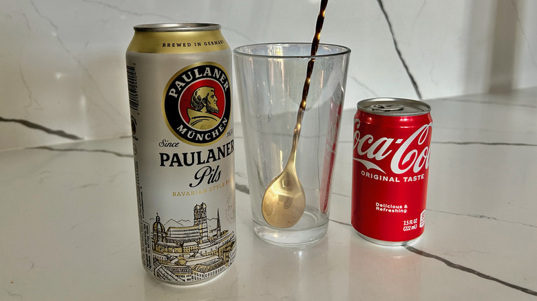 can of German beer, empty glass, and Coca-Cola 