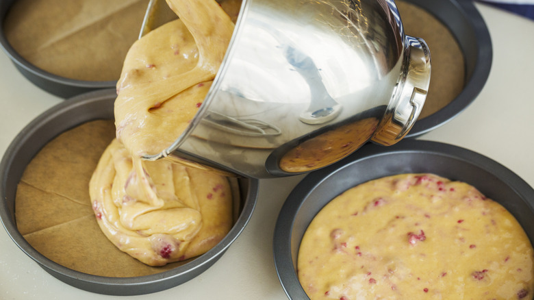 pouring cake mix into pans