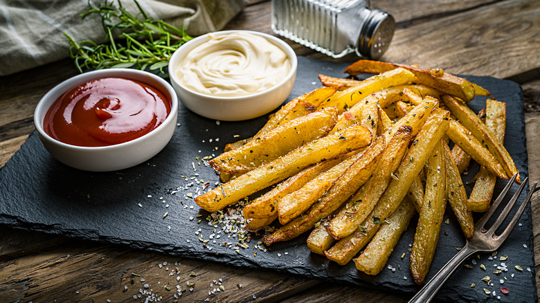 plate of french fries with ketchup and mayonnaise