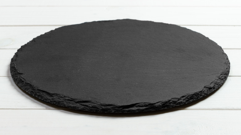 A black, slate pizza stone