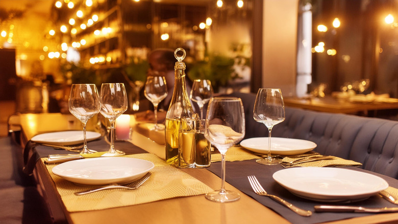 A restaurant table set for four with olive and condiments at the center