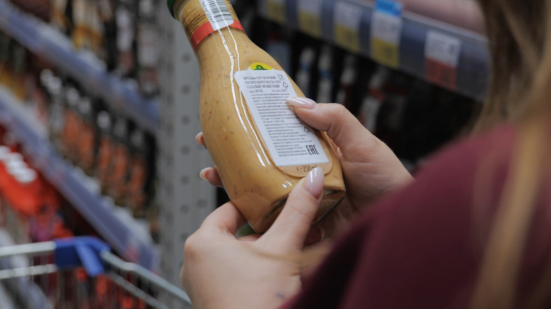 Person reading salad dressing label