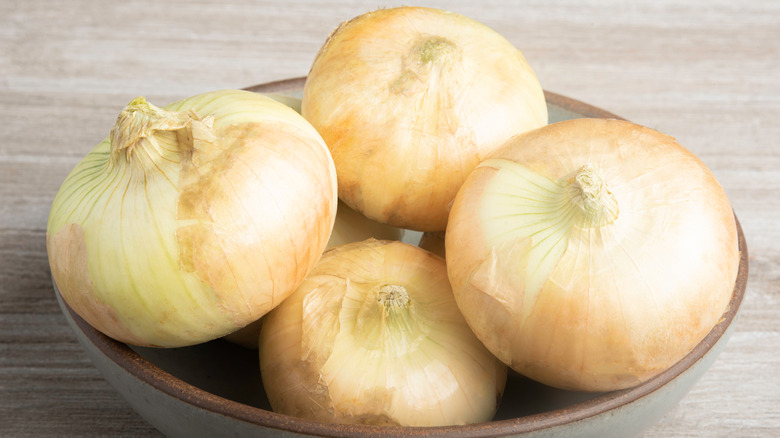 unpeeled Vidalia onions in a bowl