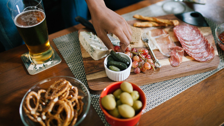 hand picking food from charcuterie board