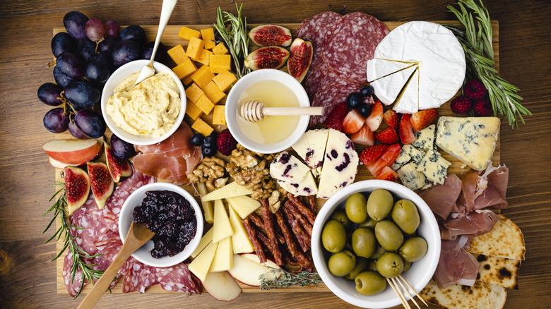 charcuterie board with meat, cheese, and produce