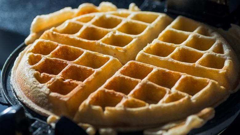 A cooked waffle inside a waffle maker