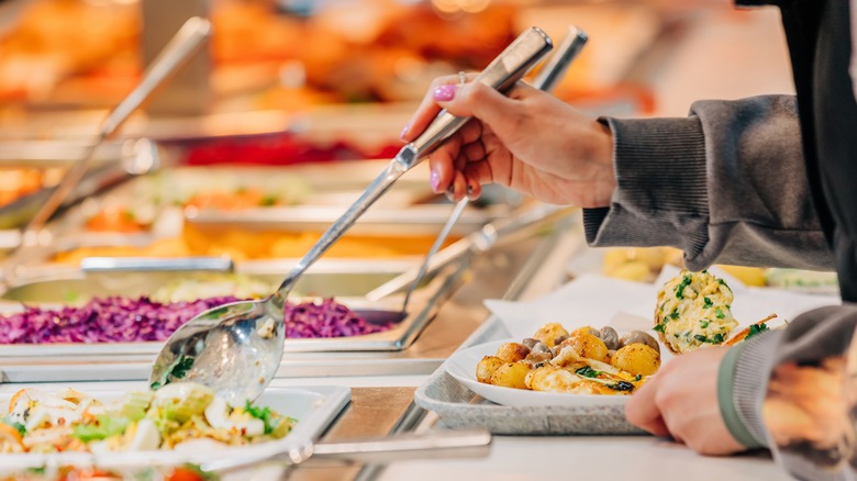 hand spooning food at buffet