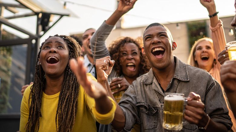 people cheering, holding beer