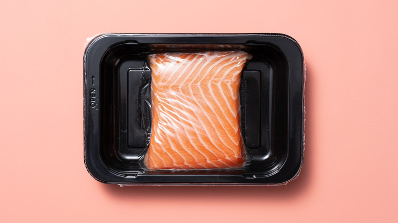 Vacuum sealed salmon in a black container.