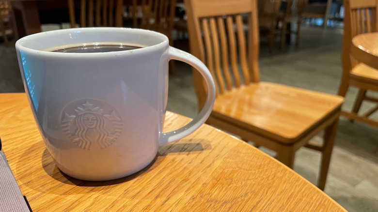 Plain white mug of Starbucks coffee on table