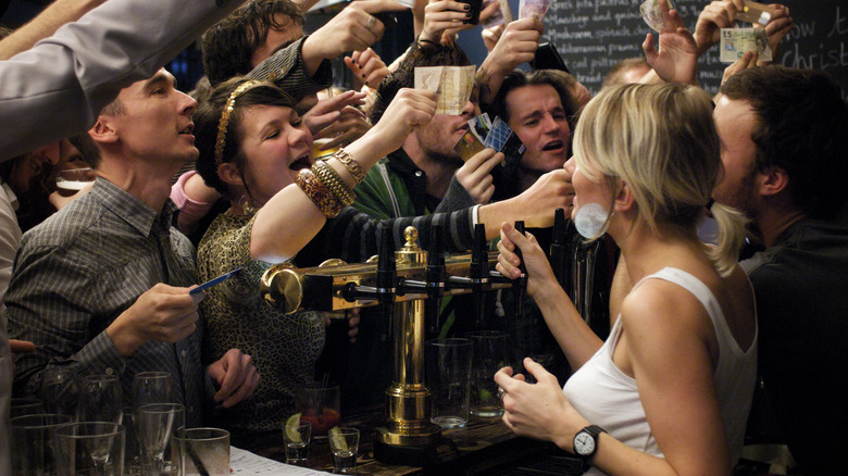 Customers yell for bartenders' attention in a crowded bar