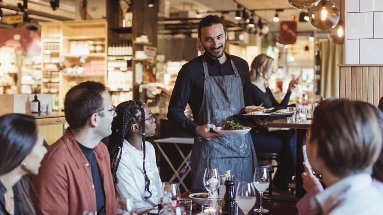 server speaking to restaurant guests