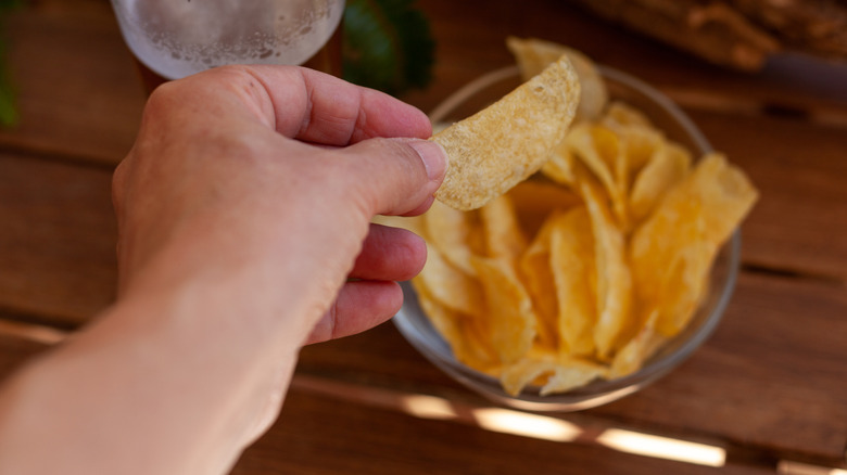 A person holding a potato chip.