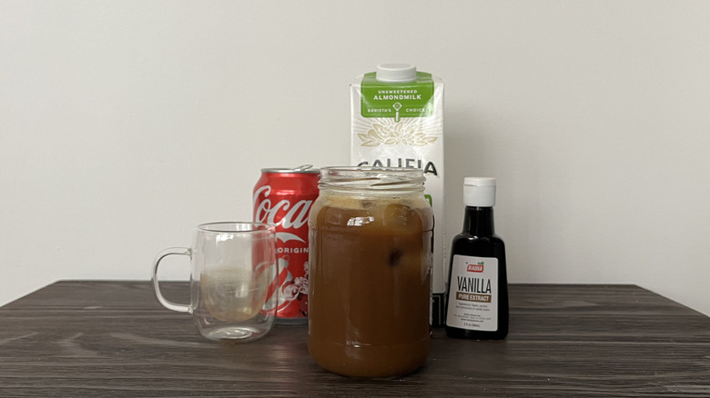 Coke with espresso and cream in front of its ingredients