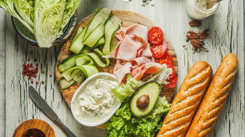 sandwich ingredients chopped and sliced on a wooden cutting board