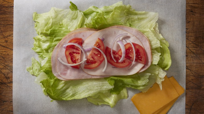 Sandwich vegetables, turkey, and cheese on parchment paper