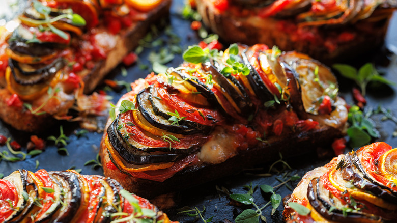 An open face ratatouille sandwich sprinkled with fresh herbs