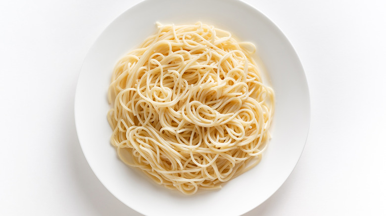 Spaghetti on a white plate against a white background