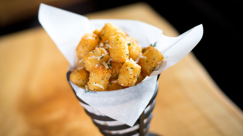 Tater tots with herbs and parmesan cheese in cone