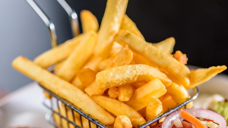 up close photo of french fries in a frying basket