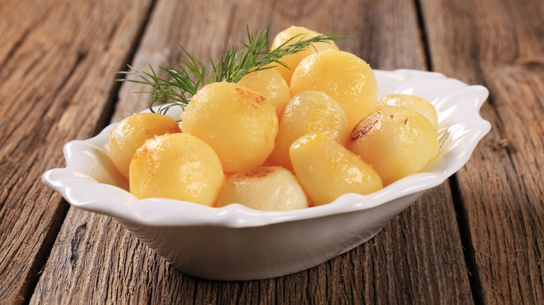 Round balls of parisian potatoes in a white dish