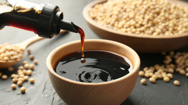 Soy sauce poured into wooden ramekin